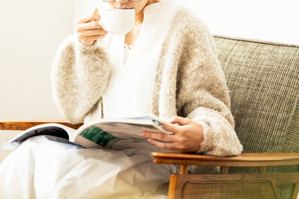 お茶を飲みながら注文住宅の本を読む女性