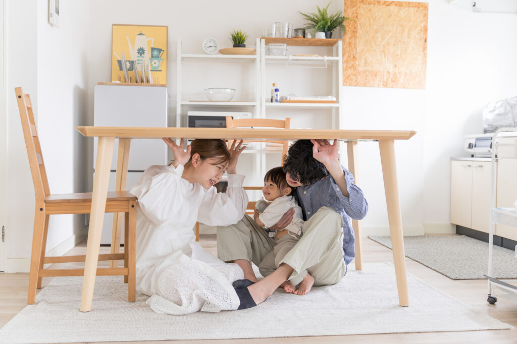 家の中で机の下に避難する家族